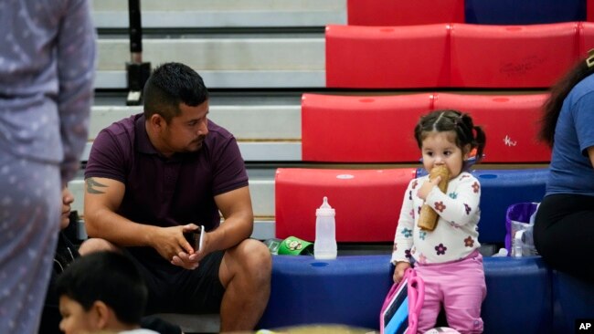 Seorang pria duduk bersama keluarganya di tempat penampungan di Fairview Middle School sebelum Badai Helene melana di Leon County, Florida, 26 September 2024. (Foto: Gerald Herbert/AP Photo)