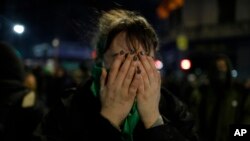 A pro-choice activist holds her face after lawmakers voted against a bill that would have legalized elective abortion in the first 14 weeks of pregnancy, outside Congress in Buenos Aires, Argentina, early Aug. 9, 2018. Argentina allows the procedure only in cases of rape or risks to a woman's health. 