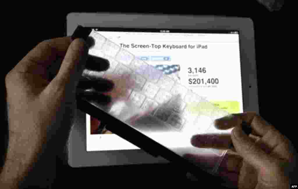 In this Dec. 15, 2011 photo, Steven Isaac, CEO of TouchFire, holds his first product, a silicone overlay that goes on top of the virtual keyboard of an Apple iPad and allows typing that feels like a physical keyboard, is shown in Seattle. Development of t