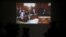 Journalists watch prosecutors and court officials on a live feed of the trial of Yuri Chaplinsky, Budapest, March 11, 2020.