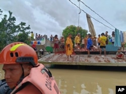 Residents hold   connected  their roofs to debar  floods caused by Tropical Storm Trami successful  Libon, Albay province, Philippines, Oct. 23, 2024. (Philippine Coast Guard via AP)