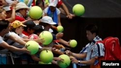 Japan's Kei Nishikori signs autographs after winning his first round match against Germany's Philipp Kohlschreiber at the Australian Open tennis tournament at Melbourne Park, Australia, January 18, 2016.