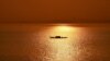 A fishing boat travels along Mekong river as sunrises over Phnom Penh on January 29, 2019.