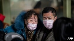 People traveling for the Lunar New Year wear protective masks as they head to the departure area at the Beijing Capital International Airport in Beijing on Jan. 22, 2020.