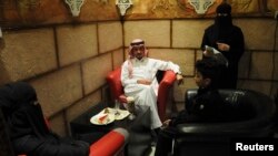 FILE - A veiled Saudi waitress (R) speaks to visitors at a coffee shop in Tabuk, 1,500 kilometers from Riyadh.