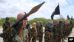 FILE - Al-Shabab fighters display weapons as they conduct military exercises in northern Mogadishu, Somalia, on Oct. 21, 2010. 