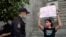 Police detain a journalist with the poster reads "Journalism Freedom", during individual pickets in Moscow, Russia, Aug. 21, 2021. 
