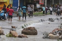 Warga berjalan melewati kawasan yang tergenang banjir setelah hujan lebat melanda Hyderabad, India, India, Rabu, 14 Oktober 2020.