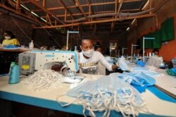A worker sews surgical-type face masks to be used to curb transmission of the new coronavirus, at the New Dawn company in Kikuyu, north of Nairobi, in Kenya, April 4, 2020.