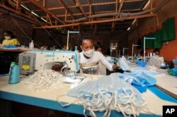 A worker sews surgical-type face masks to be used to curb transmission of the new coronavirus, at the New Dawn company in Kikuyu, north of Nairobi, in Kenya, April 4, 2020.