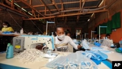 A worker sews surgical-type face masks to be used to curb transmission of the new coronavirus, at the New Dawn company in Kikuyu, north of Nairobi, in Kenya, April 4, 2020. 
