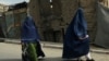 Afghan women in burqas walk on a street in Kabul, Afghanistan, Aug. 22, 2021.