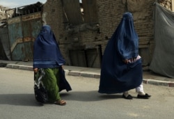 Afghan women clad in burqas walk on a street in Kabul, Afghanistan, Aug. 22, 2021.