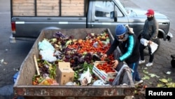 ARCHIVO - Un hombre busca alimentos entre frutas y verduras descartadas por los comerciantes en el Mercado Central de Buenos Aires, en medio de una profunda crisis económica. Foto del 12 de setiembre de 2023.