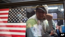 ARCHIVO - Solicitantes de asilo son vistos dentro de un autobús frente al Hotel Roosevelt el 19 de mayo de 2023 en Nueva York, EEUU.