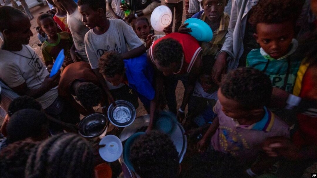 Men who fled the conflict in Ethiopia's Tigray region receive rice from charity organization Muslim Aid at a camp in Qadarif, Sudan, Nov. 27, 2020. Ethiopian Prime Minister Abiy Ahmed again ruled out dialogue with leaders of the Tigray region Nov. 27.