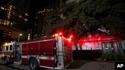 A firetruck is positioned outside the Chinese Consulate, July 22, 2020, in Houston. Witnesses said that people were burning paper in what appeared to be trash cans, according to police.