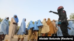 Un officier de police garde des filles qui ont été enlevées d'un pensionnat dans l'État de Zamfara, au nord-ouest du Nigeria, après leur libération, le 2 mars 2021. 