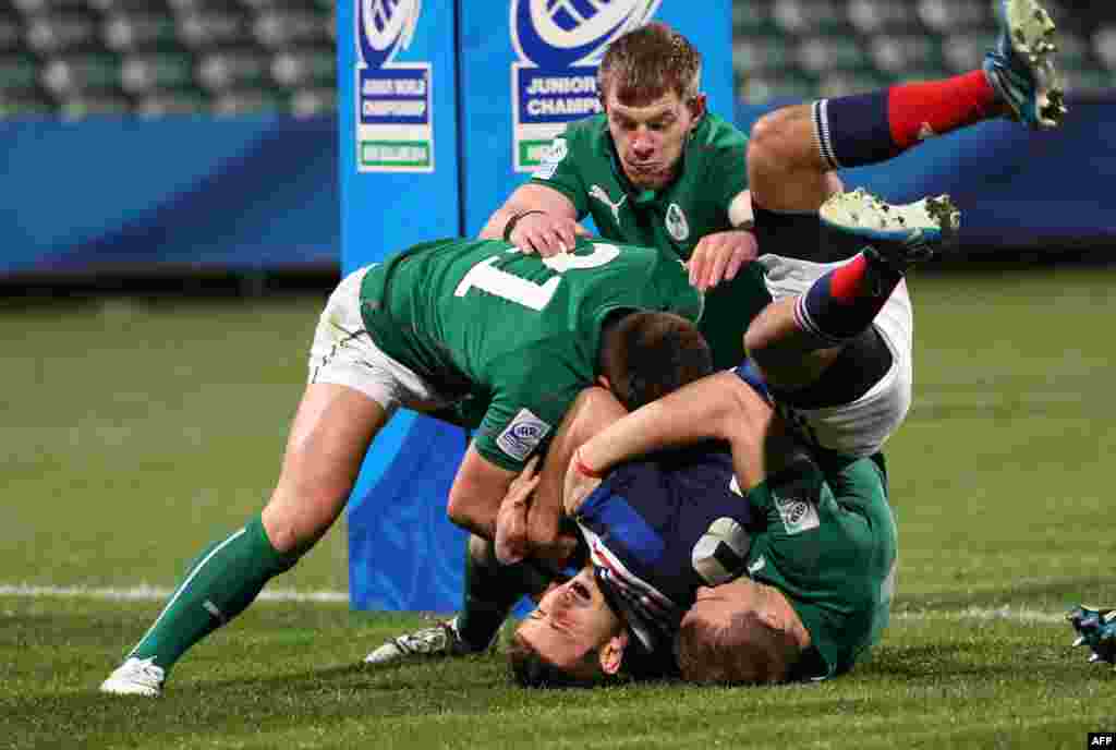 Francois Bouvier (C) of France is held up over the try line by Ireland&#39;s Ryan Foley (L), Stephen Gardiner (R) and Garry Ringrose (behind) during the U20 Junior World Championship rugby union match at Albany Stadium in Auckland, New Zealand.