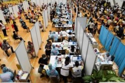 FILE - People receive the first dose of AstraZeneca COVID-19 vaccine  as Thailand starts a mass inoculation at a gymnasium inside the Thammasat University in Pathum Thani, Thailand, June 7, 2021.