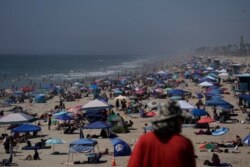 La gente se agolpa en la playa de Huntington Beach, California, el 5 de septiembre de 2020. California se está sofocando bajo una peligrosa ola de calor el fin de semana del Día del Trabajo que extendió temperaturas de más de 100 grados F, 38 C.