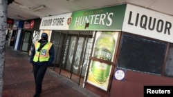 FILE PHOTO: A security guard stands outside a liquor store closed under the coronavirus disease (COVID-19) lockdown regulations that prohibit alcohol sales in Cape Town, South Africa, Aug. 13, 2020. 