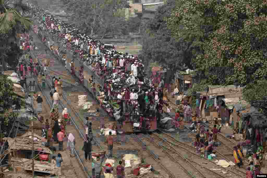 Commuters ride on the roof of a train as they come back to the city after attending the final prayer of Biswa Ijtema in Dhaka, Bangladesh.
