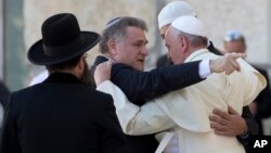 FILE - Pope Francis embraces two good friends traveling with him, Argentine Rabbi Abraham Skorka, center, and Omar Abboud, leader of Argentina's Muslim community, partially seen next to the Pope, after praying at the Western Wall in Jerusalem's Old City, Israel, May 26, 2014.