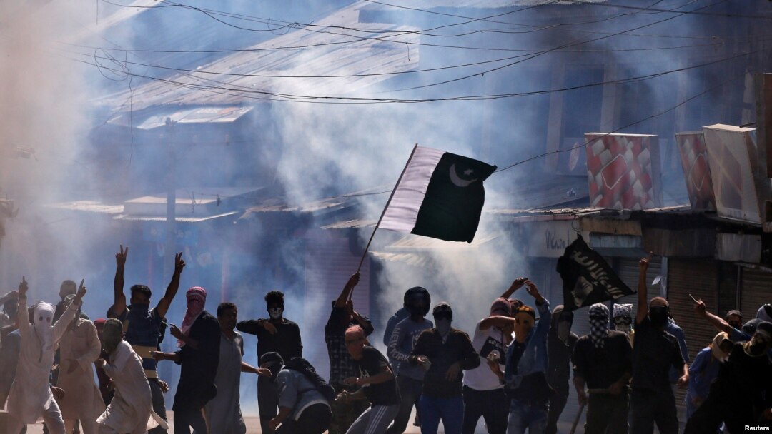 بھارت کے زیرِ انتظام کشمیر میں مظاہرین پاکستان کا پرچم لہرا رہے ہیں۔ (فائل فوٹو)