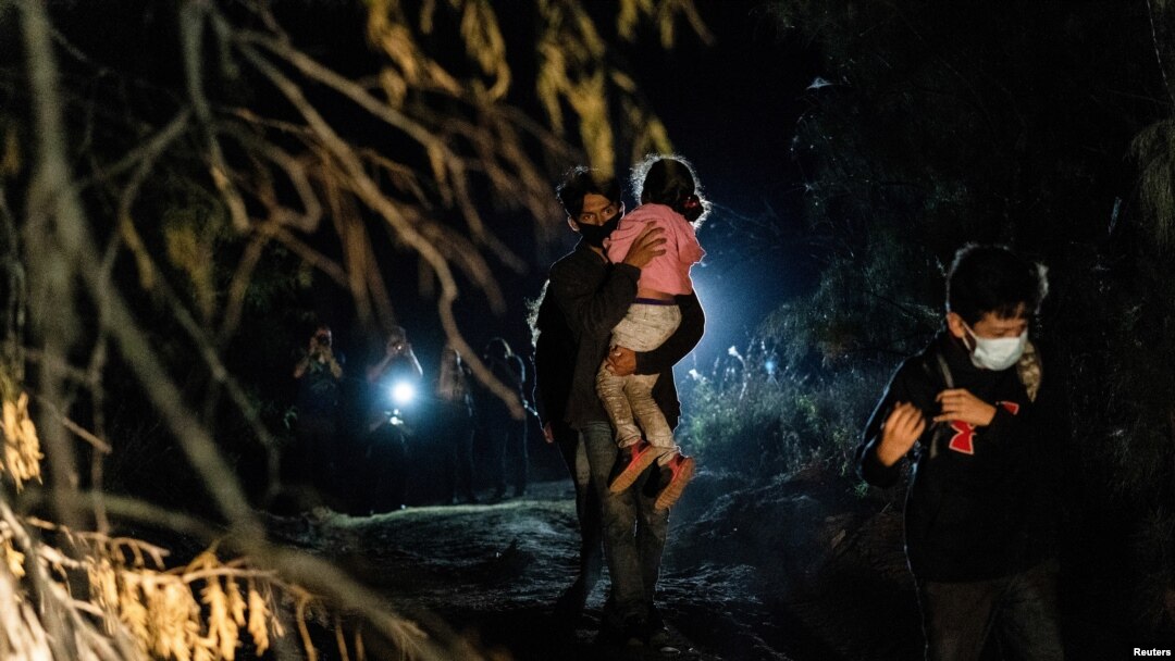 Asylum-seeking migrant families walk to turn themselves in to the U.S. Border Patrol after crossing the Rio Grande river into the United States from Mexico in Roma, Texas, April 27, 2021. (REUTERS/Go Nakamura)
