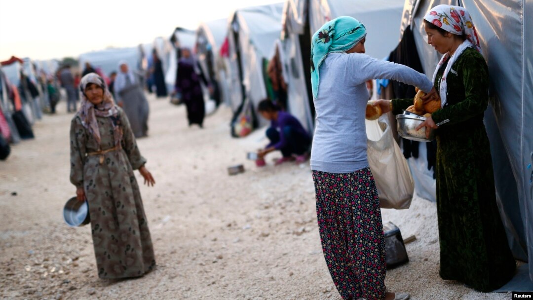 Người Kurd từ thành phố Kobani ở Syria, tại một trại tị nạn ở thị trấn Suruc, tỉnh Sanilurfa chia nhau thực phẩm, 17/10/14