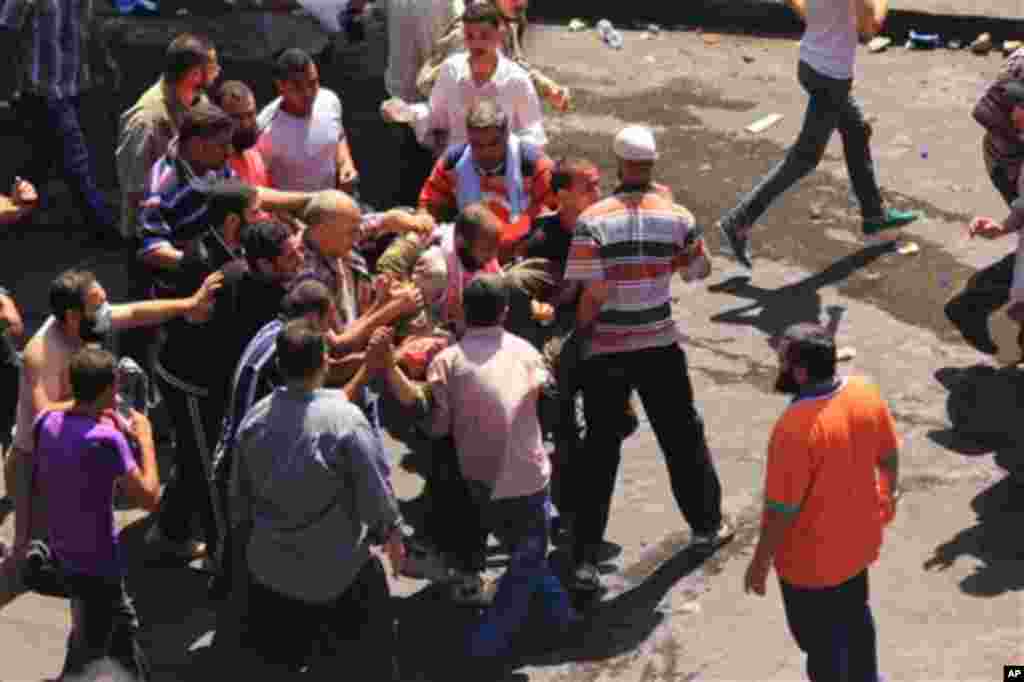 Supporters of Egypt's ousted President Mohammed Morsi carry a wounded comrade during clashes with security forces.