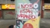 Protesters’ call of “Nos Están Matando," or "They’re Killing Us," covers up Medellín government’s coronavirus public relations campaign slogan in Medellín, Colombia. (Megan Janetsky/VOA)