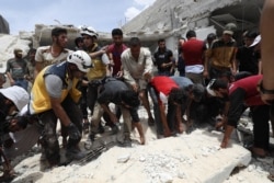 FILE - Syrian rescue teams and civilians search for survivors amid rubble in a bombarded area following a reported airstrike by regime forces and their allies on the market town of Kfar Ruma in Syria's northwestern Idlib province, May 30, 2019.