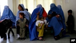 Afghan women clad in burqas sit with their children, at the Indira Ghandi Children's Hospital in Kabul Afghanistan.