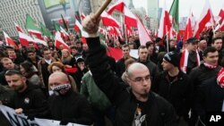 Right-wing protesters wave flags at the start of the Independence Day march organized by nationalist parties, in Warsaw, Poland, Nov. 11, 2014. 