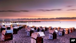 FILE - Beach chairs are lined up before sunrise in Timmendorfer Strand at the Baltic Sea, northern Germany, Aug. 21, 2018. 