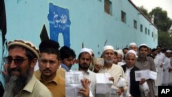 Men line up to cast their votes outside a polling station in Jalalabad east of Kabul, Afghanistan, Sept. 28, 2019. 