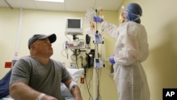 Brian Madeux looks up at nurse practitioner Jacqueline Madde while receiving the first human gene editing therapy at the UCSF Benioff Children's Hospital in Oakland, California, Nov. 13, 2017.