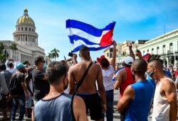 FILE - Cubans are seen outside Havana's Capitol during a demonstration against the government of Cuban President Miguel Diaz-Canel in Havana, July 11, 2021.