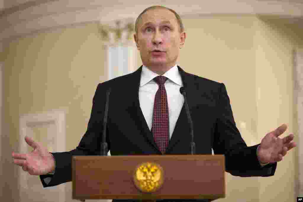 Russian President Vladimir Putin gestures as he speaks to the media after the peace talks in Minsk, Belarus, Thursday, Feb. 12, 2015.