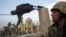 A U.S. soldier watches as a statue of Iraq's President Saddam Hussein falls in central Baghdad in this photo dated April 9, 2003.
