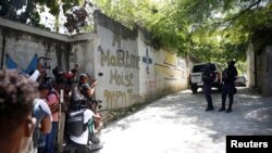 Periodistas se reúnen junto a los agentes de policía que hacen guardia cerca de la residencia privada del presidente de Haití, Jovenel Moise, después de que hombres armados lo mataran a tiros con rifles de asalto, Puerto Príncipe, el 7 de julio de 2021.