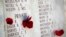 Poppies decorate a commemorating wall with the names of fallen servicemen at the Lone Pine cemetery and memorial site in Gallipoli peninsula, Turkey, April 23, 2015.