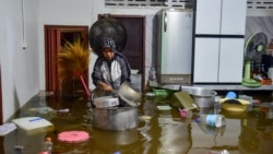 Seorang warga memeriksa barang-barangnya yang hanyut akibat banjir di rumahnya di Narathiwat, Thailand, 28 November 2024. (Foto: AFP)