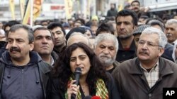 Peace and Democracy Party (BDP) Parliamentarians Sebahat Tuncel (C) and Ufuk Uras (R) attend a protest against the High Election Board's decision in central Istanbul, April 19, 2011