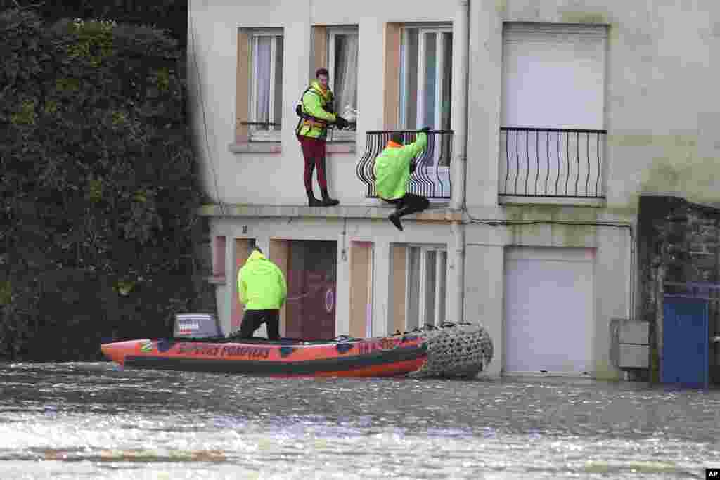 Rescuers secure houses in the center of Quimperle, western France, which has been flooded by the Laita river. Floods caused by heavy rains left the streets of some coastal towns underwater. 