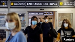 Travelers exit Ben Gurion International Airport as Israel imposes new coronavirus disease restrictions near Tel Aviv, Israel, Nov. 28, 2021.