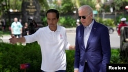 Presiden Joko Widodo menyambut Presiden AS Joe Biden dalam acara penanaman gambut di sela-sela KTT G-20 di Denpasar, Bali, 16 November 2022. (Foto: Dita Alangkara/Pool via Reuters)