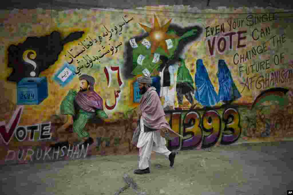 A man walks pass election graffiti urging people to go to the polls in Kandahar, southern Afghanistan.